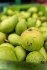 Vertical close-up of green mangoes with ripe texture