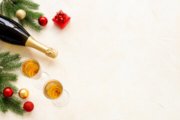 Christmas decoration top view - fir tree branch with champagne bottle and two glasses. Festive flat table setting