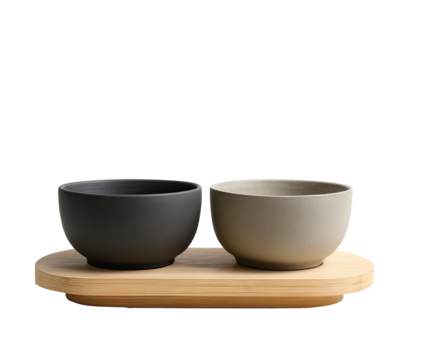 Two bowls, dark & light, sit on a light wooden tray. Minimalist setup