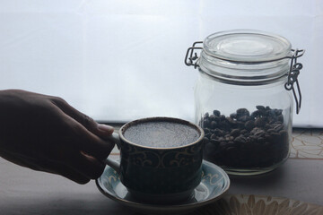 holding a cup of hot coffee