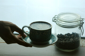 holding a cup of hot coffee