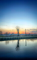 A beautifully serene sunset with vibrant and rich colors reflecting on the calm and still waters...