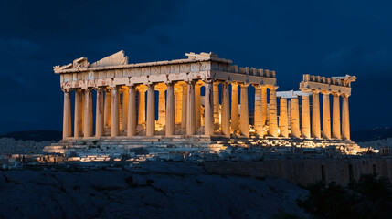 Lit ancient pillars and classic ruins dominate the nighttime skyline, golden glow and shadows reveal architectural beauty
