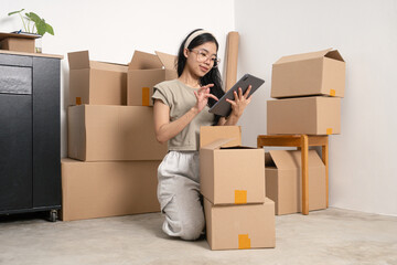 Fototapeta premium young woman using tablet to order services while moving house