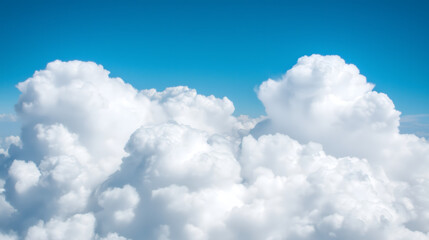 Clear blue sky filled with puffy clouds, sunlight making each shape bright for a happy and open atmosphere.