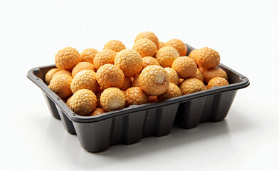 Tray filled with round caramel popcorn balls on white background, close-up of crunchy sweet snack in black plastic container.