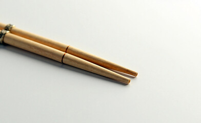 Close-up of wooden chopsticks on light background, minimal composition highlighting natural bamboo texture and elegant simplicity.