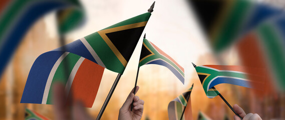 South Africa flags in their hands on a blurred urban background