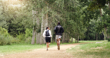 Obraz premium Running, forest and back of couple for fitness, exercise and cardio workout together in morning. Nature, hiking trail and man with woman training for wellness, health and challenge outdoor for hobby