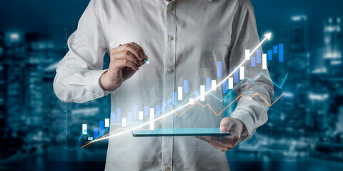 A businessman is analyzing stock market trends using a digital graph displayed on a tablet in an urban setting, showcasing financial growth dynamics. Impute