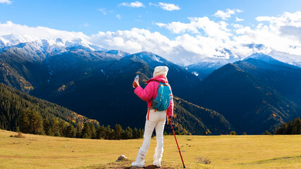 Asian woman as her dog rest and enjoy of the view as sitting on a chair. Hiking in nature.  in Mestia Mountain ,Georgia