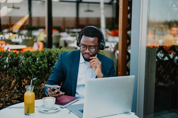 Black man working remotely using laptop in cafe