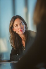 Confident thoughtful businesswoman in modern office setting, engaged in focused meeting, professional woman in corporate environment, workplace dynamics, leadership, career success
