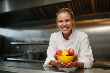 Smiling female chef presenting fresh tomatoes in modern commercial kitchen professional culinary expertise gourmet organic ingredients hospitality industry