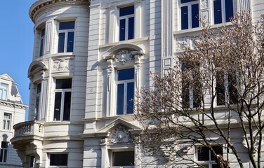 A white neo-classical building facade with detailed stucco work in a European city Antwerp, Belgium. Architecture, typical of neighborhoods Zurenborg.