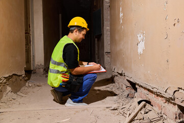 Construction worker inspects repair site in an old building