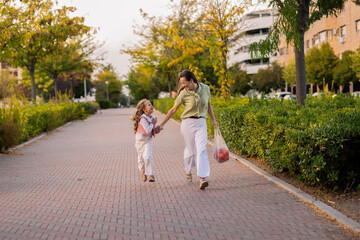 Mother and daughter running laughing holding hands