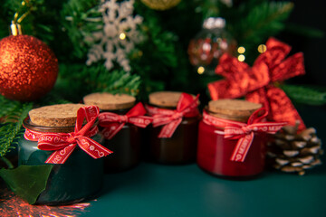 Christmas aroma candles with fir cones on the table with the Christmas tree on a background, copy space
