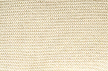 Full frame close-up of natural cream-colored canvas or linen fabric texture with a tight weave pattern. Perfect minimalist background for art, fashion, organic, and textile design.