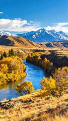Fototapeta premium Autumn river winds through golden hills to snowy peaks