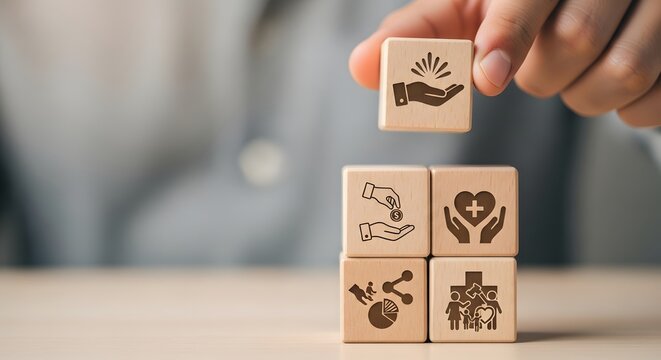 Hand placing a value icon block with charity, healthcare, community symbols, representing core principles of social responsibility and collective welfare initiatives