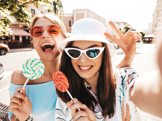 Two young beautiful smiling hipster female in trendy summer clothes. Sexy carefree women posing on...
