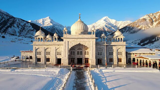 Gurudwara shri manikaran sahib covered with snow in himachal pradesh india with mountains in the background on a sunny day guru nanak jayanti