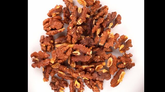 A video of walnuts are being rotating on white background.