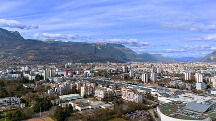 Naklejka premium Urban panorama with apartment buildings and mountains under blue sky