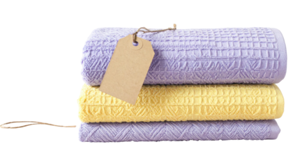 Stack of three towels (purple, yellow, purple) with geometric patterns and attached tag against a black background