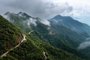 Winding mountain road through lush green hills and clouds