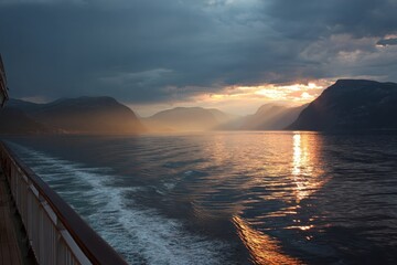 Stunning midnight sun illumination over the fjord viewed from the deck of a cruise ship during a scenic journey in Norway
