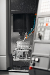 The CNC milling machine cutting the mold parts with oil coolant method. The mold and die manufacturing process by CNC machining center.