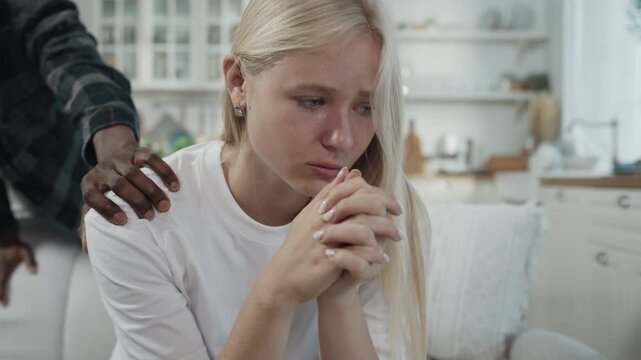 African american boyfriend and blonde caucasian girlfriend quarrelling at home. Bad relationship and breakup, psychological abuse and pressure, interracial marriage of young man and woman, crying lady