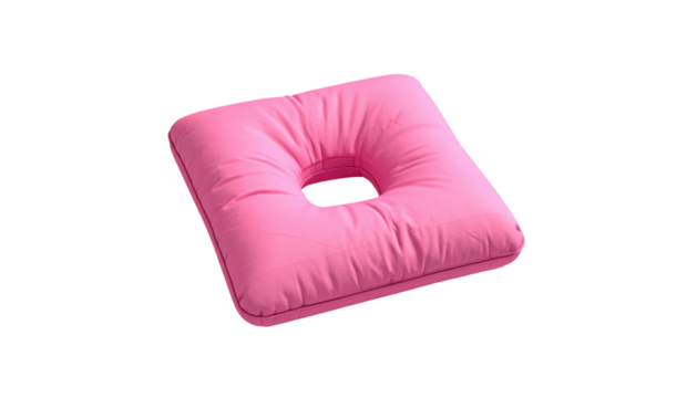 Pink square cushion with a central circular hole, set against a stark black background, casting soft shadows