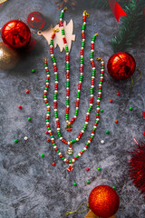 Christmas themed handmade jewelry on a stone background surrounded by Christmas balls.