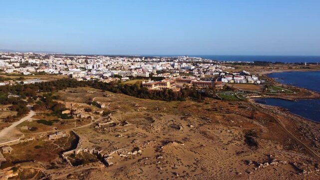 An aerial sweep reveals the vast necropolis of ancient rock‑cut tombs, once the aristocratic burial site in Cyprus, carved into sandstone cliffs under the Mediterranean sun