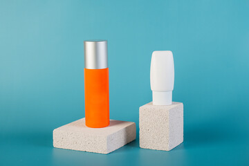 Skin care or sunscreen cosmetic with stylish props on blue background.