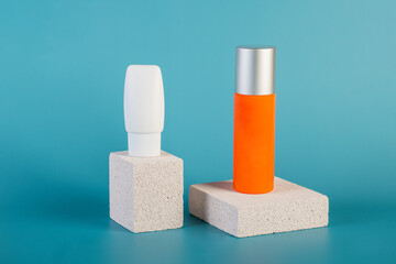 Skin care or sunscreen cosmetic with stylish props on blue background.