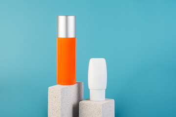 Skin care or sunscreen cosmetic with stylish props on blue background.