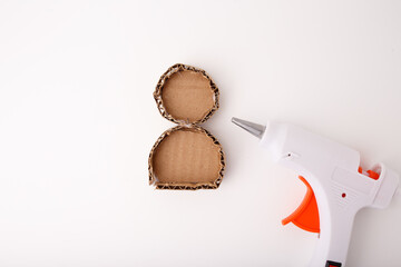 Two glued cardboard shapes forming figure of a snowman or reindeer base made from corrugated paper on white background. DIY craft step-by-step process. Design for craft tutorial