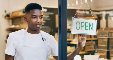 Black man, cafe or welcome with open sign on door for small business or ready for service. Male person, waiter or entrepreneur with label or entrance for trade hour, coffee shop startup or restaurant