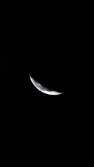 A minimalistic photo of a crescent moon glowing in the deep black night sky. Perfect for backgrounds, astronomy themes, night photography collections, and inspirational designs. The image captures the