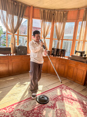 A young man enjoys singing into a microphone in a sunny room filled with vintage items