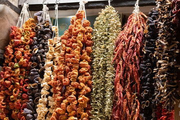 Colorful strings of dried peppers and vegetables hang in an Istanbul market