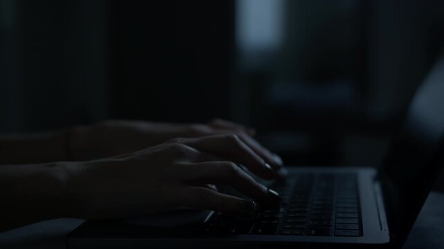 Typing on laptop in dark blackout room