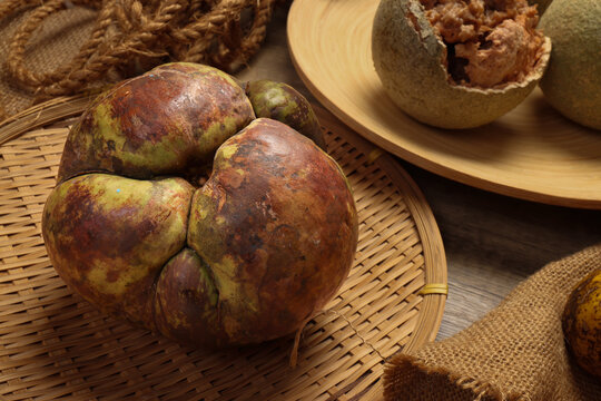 Unique exotic rare Asian green elephant apple chalta ou tenga fruit tangi sour ingredients on rustic plate background