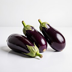 Three fresh glossy deep purple eggplants with vibrant green calyxes and stems on a bright white studio background