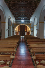 Fototapeta premium Symmetrical Church Aisle Leading to Doors, Arched Side Naves and Wooden Ceiling
