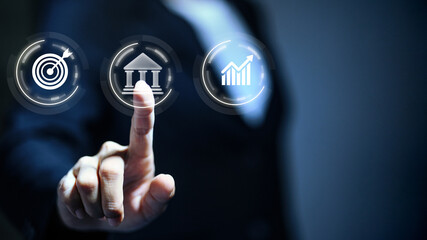 Fototapeta premium Businessman touching virtual interface with target, banking, and growth icons for financial strategy and success